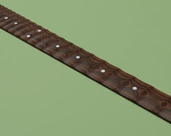 May include: A dark brown scalloped guitar fretboard featuring a wood grain pattern, metal frets, and small circular white position markers embedded along the length of the fingerboard, presented at an angle against a solid light green background.