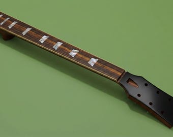 May include: A guitar neck featuring a dark brown wood fretboard with prominent wood grain patterns, inlaid with rectangular pearlescent position markers. The headstock is finished in a solid matte black with six pre-drilled tuning peg holes.