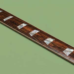 May include: A long, rectangular guitar fretboard made of dark brown wood with a prominent grain pattern. It features multiple silver metal frets and inlaid trapezoidal markers made of iridescent, pearlescent material positioned along the surface.