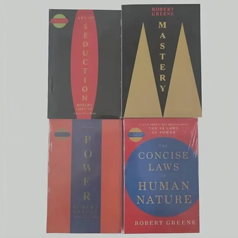 May include: Four books by Robert Greene arranged in a grid. Top left: Art of Seduction with a red oval. Top right: Mastery with gold triangles. Bottom left: Power with a blue vertical stripe. Bottom right: The Concise Laws of Human Nature with a blue circle.