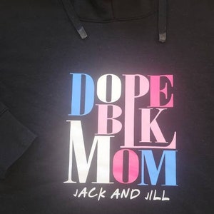 May include: Black hooded sweatshirt with the text "DOPE BK MOM" in pink, blue, and white letters. The text "JACK AND JILL" is printed below the main text.