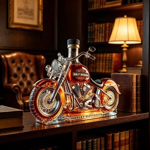Puede incluir: Un decantador de vidrio con forma de motocicleta que contiene líquido ámbar. El tanque muestra el logotipo de Harley-Davidson y la base tiene la inscripción Harley-Davidson. El diseño incluye manillares y ruedas de color cromo.