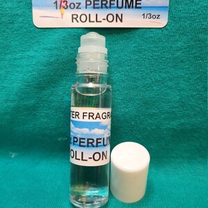May include: A clear glass roll-on bottle with a white cap. The bottle is labeled "BLUE WATER FRAGRANCES" and "1/3oz PERFUME ROLL-ON".