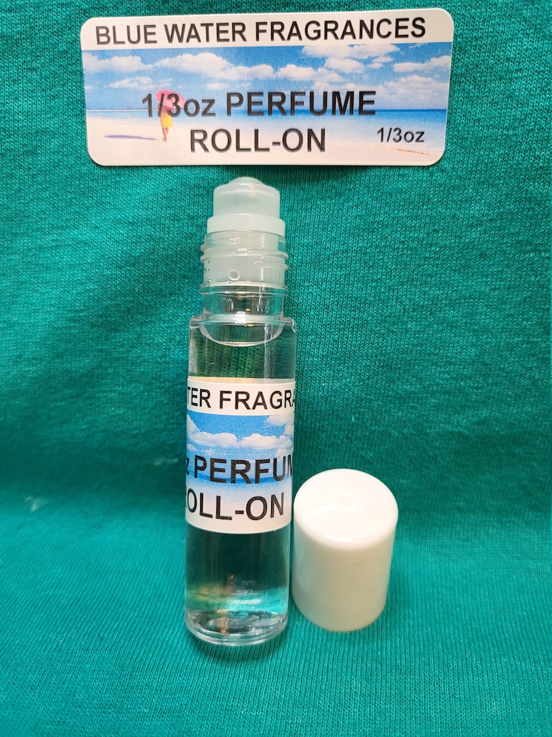 May include: A clear glass roll-on bottle with a white cap. The bottle is labelled "BLUE WATER FRAGRANCES" and "1/3oz PERFUME ROLL-ON".