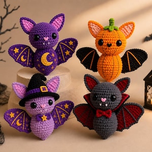 Könnte beinhalten: Vier gehäkelte Plüschtiere mit Halloween-Motiven. Eine lila Fledermaus mit Mond- und Sternenstickerei, eine orangefarbene kürbisförmige Fledermaus, eine helllila Fledermaus mit Hexenhut und eine graue Fledermaus mit rotem Umhang und Fliege.
