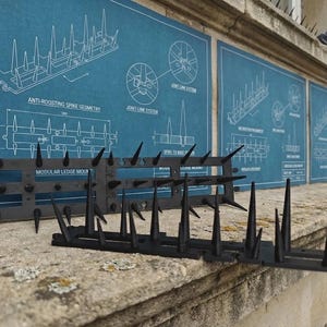 Op de afbeelding: Zwarte kunststof anti-landingspinnen met een modulair ontwerp voor montage op richels. De pinnen worden getoond voor blauwe technische blauwdrukken die de geometrie, het verbindingssysteem en het basispatroon van de pinnen beschrijven.