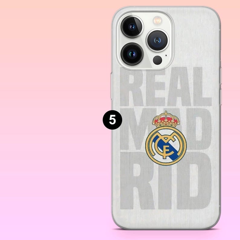 May include: A clear smartphone case featuring a brushed silver metallic background with the text REAL MADRID in large light gray letters and the official Real Madrid football club crest in blue, gold, and red colors centered on the back.