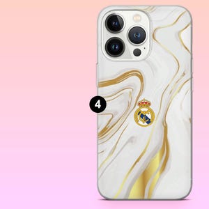 May include: A smartphone case featuring a white and gold marble pattern with a Real Madrid football club logo centered on the back. The case has a cutout for the triple camera system and flash. A black circle with the number 4 is visible.