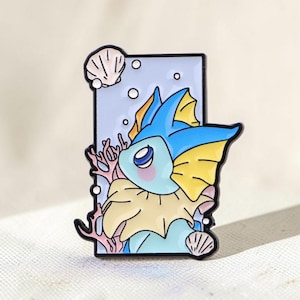 May include: A rectangular enamel pin featuring a light blue creature with yellow fins and a cream-colored collar. The design includes pink coral, white seashells, and small bubbles against a light blue background, all outlined in black metal.