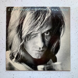 May include: Black and white photo of Eddie Money on the cover of his album "Playing for Keeps".