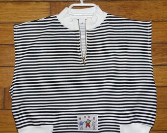 Puede incluir: Una prenda sin mangas de cuello alto con un patrón de rayas horizontales en blanco y negro. La pieza cuenta con una cremallera frontal dorada a media altura y un cuello y dobladillo de canalé blanco. Incluye un parche rectangular con el texto NEKO.