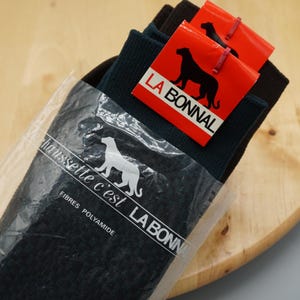 Puede incluir: Un par de calcetines azul marino oscuro en un empaque de plástico transparente. El empaque presenta el texto "La chaussette c'est LA BONNAL" y "FIBRES POLYAMIDE" con un logo de pantera. Una etiqueta roja muestra "LA BONNAL".