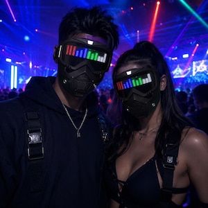 Puede incluir: Dos máscaras faciales completas de color negro con pantallas LED integradas que muestran barras de ecualizador de sonido verticales de colores. Las máscaras tienen un diseño táctico elegante con lentes oscuras y rejillas de ventilación.