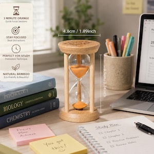 May include: A bamboo hourglass with orange sand, measuring 4.8 cm in diameter and 9.5 cm in height. The top wooden frame features an engraved icon, and the clear glass bulbs contain fine orange sand, designed for tracking short time intervals.