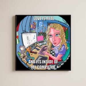 May include: A square framed print featuring a cartoon illustration of a blonde person at a desk with a computer, keyboard, and various small toys. The text reads LOVE IS REAL AND ITS INSIDE OF MY COMPUTER. The scene is rendered in a vibrant, colorful style.