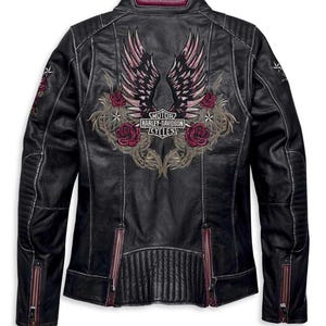 May include: A black leather jacket featuring a large embroidered graphic on the back with wings, red roses, and the text Motor Harley-Davidson Cycles. The jacket includes quilted shoulder and lower back panels, and zippered cuffs and side vents.