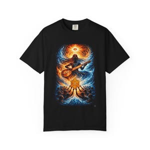 Peut inclure: Un t-shirt noir avec une impression graphique vibrante représentant une silhouette jouant d'un instrument à cordes au milieu d'un tourbillon d'énergie bleue et orange. Un œil brillant surplombe la scène, au-dessus d'un emblème doré central.