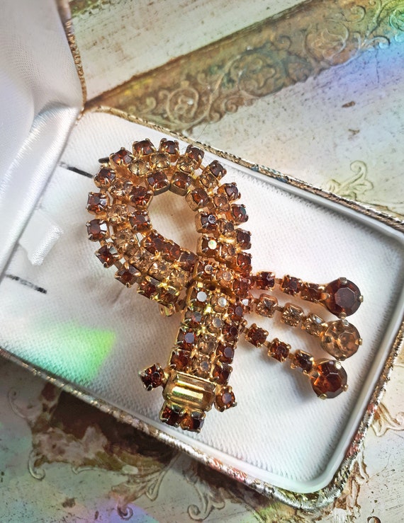 Broche laiton avec strass brun et au centre un cabochon de couleur