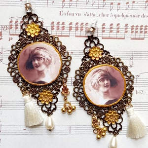 Orecchini con ritratto in bronzo del 1900, pigmenti dorati, perle e pompon