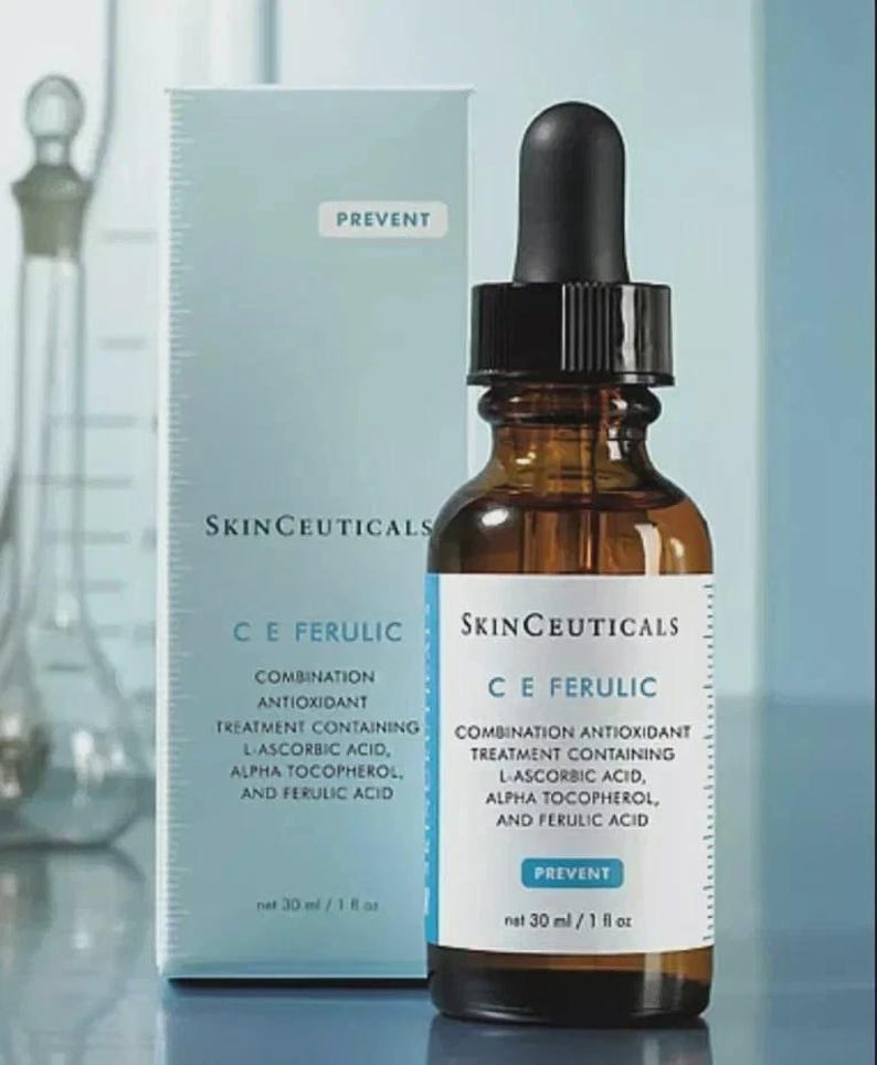 May include: A brown glass dropper bottle and a light blue box of SkinCeuticals C E Ferulic combination antioxidant treatment. The label and box text list L-ascorbic acid, alpha tocopherol, and ferulic acid. The volume is 30 ml / 1 fl oz.