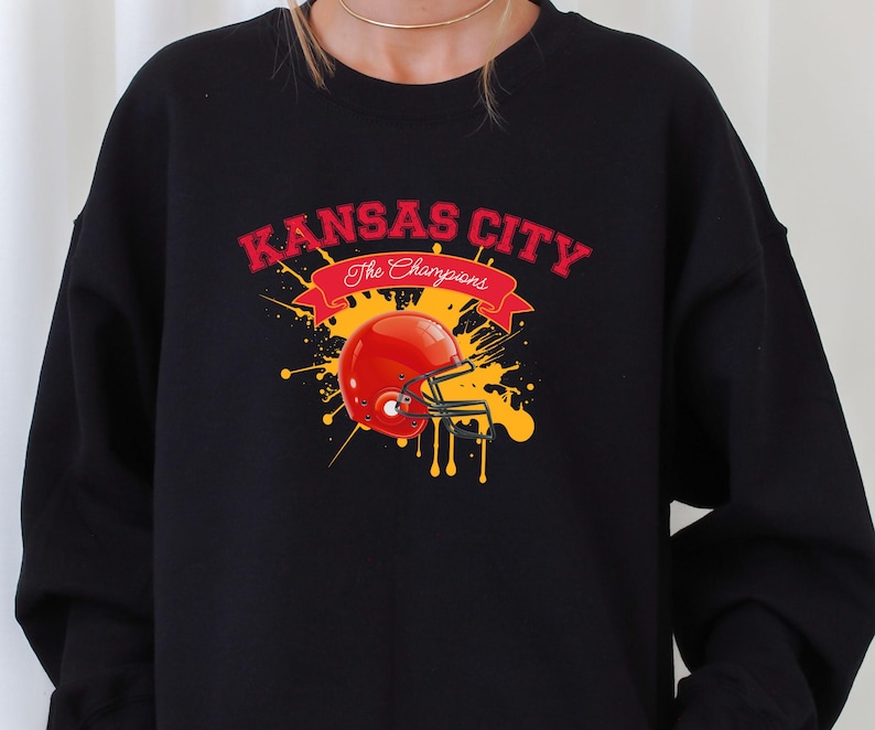 a woman wearing a black sweatshirt with a football helmet on it