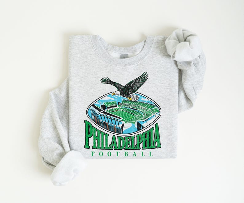 A gray sweatshirt with a graphic of Philadelphia Eagles football stadium and an eagle in flight.