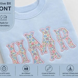 May include: A light blue sweatshirt featuring the embroidered letters BMR in a floral pattern with pink, blue, and green flowers. The letters are outlined in pink thread. Text on the image includes Native BX FONT Made for Embroidery.