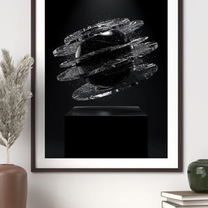 May include: A framed wall art print featuring a central black sphere surrounded by multiple horizontal, fragmented glass-like rings. The composition is set against a deep black background, with the sphere resting above a solid black rectangular pedestal.