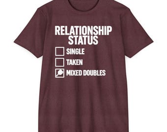Może przedstawiać: Bordowa koszulka z krótkim rękawem z białym napisem RELATIONSHIP STATUS, po którym następują trzy pola wyboru. Dwa pierwsze są puste, natomiast trzecie jest zaznaczone i opisane jako MIXED DOUBLES z ikoną rakiety do pickleballa.