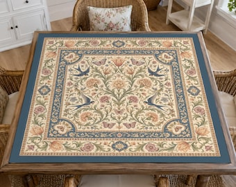 Può includere: Una tovaglia quadrata con una stampa botanica dettagliata caratterizzata da motivi floreali simmetrici, farfalle e uccelli nei toni del blu, crema, rosa e verde. Il design include un bordo decorativo e un motivo centrale su sfondo chiaro.