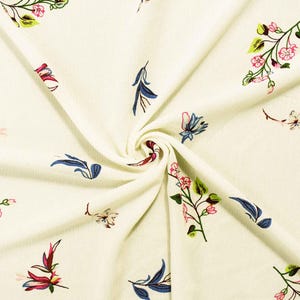 May include: A cream-colored ribbed fabric featuring a scattered floral print. The pattern consists of small pink blossoms, green leaves, and slender blue stems arranged in delicate sprigs across the textured surface of the material.