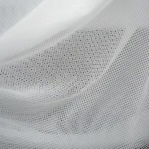 May include: A sheer white fabric featuring a fine, uniform grid of small, evenly spaced holes. The material is draped to create soft, flowing folds, highlighting the translucent quality and the consistent geometric mesh pattern of the textile.