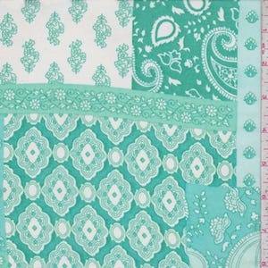 May include: A fabric swatch featuring a patchwork of teal and white patterns, including floral motifs, paisley swirls, and geometric shapes. A vertical ruler on the right side shows measurements in inches, indicating a width of approximately 8 inches.