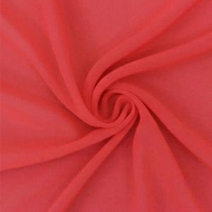 May include: A solid coral-colored fabric with a smooth, lightweight texture. The material is arranged in a central spiral swirl, creating soft, flowing folds and deep shadows that highlight the consistent, vibrant hue across the surface.