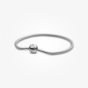 May include: A silver-toned snake chain bracelet featuring a spherical clasp. The clasp is engraved with the text PANDORA. The bracelet has a flexible, woven metal design with a polished finish, creating a continuous circular loop when closed.
