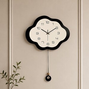 May include: A cloud-shaped wall clock with a cream-colored face and a thick black border. The clock features black numerals from 1 to 12, thin black hands, and a pendulum consisting of a thin black cord, a small wooden bead, and a black ring.