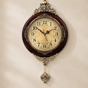 Puede incluir: Un reloj de pared redondo con marco de madera oscura y detalles metálicos dorados ornamentados. La esfera presenta números arábigos negros, un centro dorado con patrones y manecillas negras. Un péndulo dorado decorativo cuelga abajo.