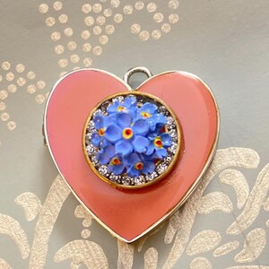 Pink Heart Locket. This pretty pink photo locket has vintage blue flowers resting on a rhinestone center. A perfect Valentine&#39;s Day gift!