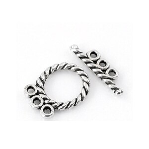 May include: Silver-toned twisted rope toggle clasp with three loops on one side and two loops on the other side.