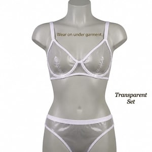 Könnte beinhalten: Ein transparentes BH- und Höschen-Set mit weißem Besatz. Der BH verfügt über Bügel-Cups und verstellbare Träger. Der Text "Wear on under garment." steht über dem BH und "Transparent Set" befindet sich rechts neben dem Höschen.