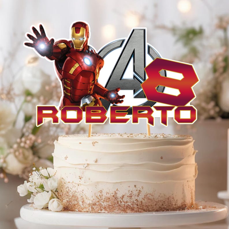 Pu&ograve; includere: Un topper per torta con una figura di Iron Man rossa e oro, il logo degli Avengers argentato, il numero 8 in sfumatura rossa e il nome ROBERTO in lettere rosse, montato su bastoncini sopra una torta bianca con granella dorata.