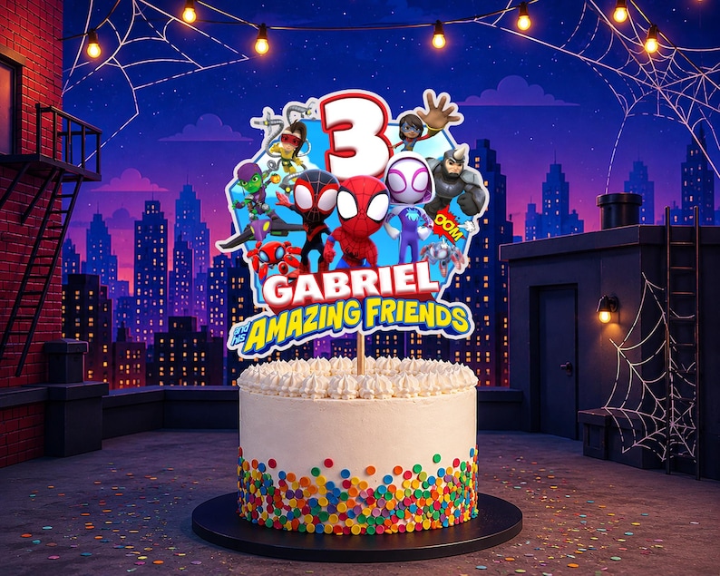 May include: A round white cake topper featuring the number 3 and cartoon characters including Spider-Man, with the text Gabriel and his Amazing Friends. The cake has white frosting and colorful round sprinkles around the base.