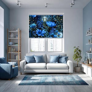 May include: A window roller blind featuring a vibrant botanical print of large blue flowers, dark green foliage, and small yellow accents against a deep navy background, installed over a window in a living room with a white sofa and blue armchair.