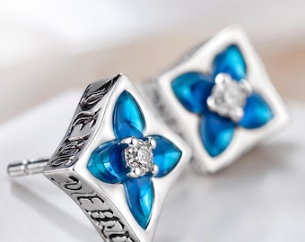 Pendientes de plata de ley con forma de flor azul y detalles de cristal de zafiro esmaltado.