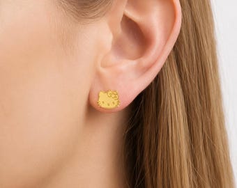 Pendientes de botón con forma de gatito en tono dorado con lazo, joyería kawaii delicada.