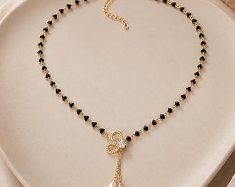 Collar con lazo de cuentas negras y colgante de perla dorada. Joyería nupcial delicada. Regalo de boda para damas de honor.