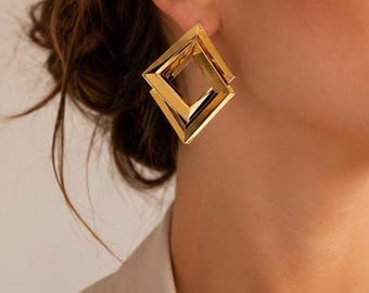 Pendientes geométricos cuadrados dorados: una joya moderna con un diseño arquitectónico impactante.