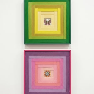 Puede incluir: Dos piezas de arte mural cuadradas con capas concéntricas de tiras de tela texturizada. El marco superior es verde y amarillo con un motivo de mariposa central. El marco inferior es rosa y morado con un patrón floral geométrico central.