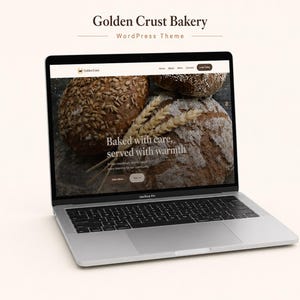 Puede incluir: Un portátil plateado que muestra el tema de WordPress Golden Crust Bakery. El sitio web presenta una imagen de hogazas de pan rústico, espigas de trigo y el texto Baked with care, served with warmth sobre un fondo oscuro.