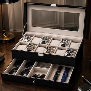 May include: A black rectangular watch storage box with a clear glass lid and a pull-out drawer. The interior features beige velvet lining with six watch compartments, two eyeglass slots, two small accessory sections, and two watch strap holders.